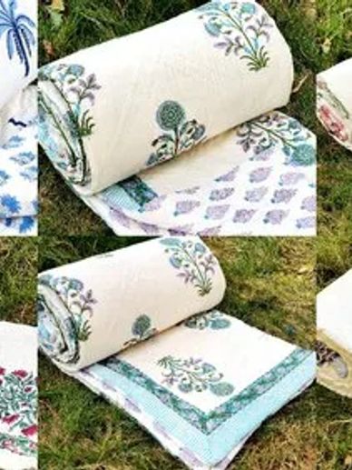 Rolled floral bedspread with green and purple patterns on grass.