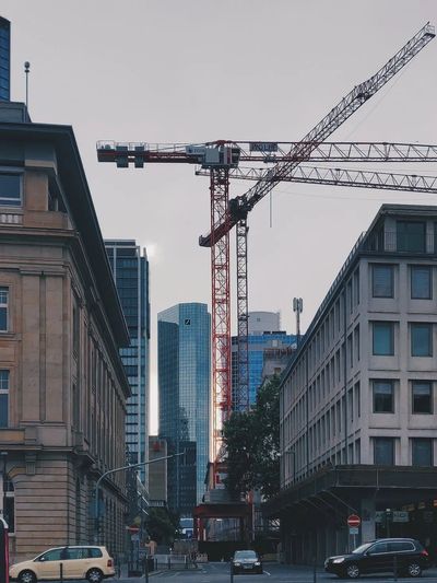 Construction crane in a city setting with office buildings.