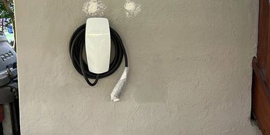 Electric vehicle charger mounted on an exterior wall.