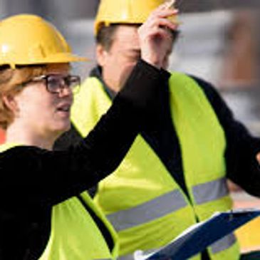 Site supervisors in safety gear discussing tasks on-site, for a safety refresher course training