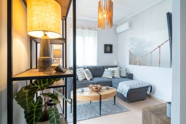 Cozy living room with a gray sectional sofa, wooden coffee table, and warm lighting.