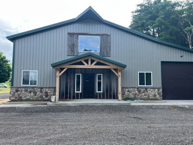 Gray outbuilding with a timber-framed entry and stone accents
