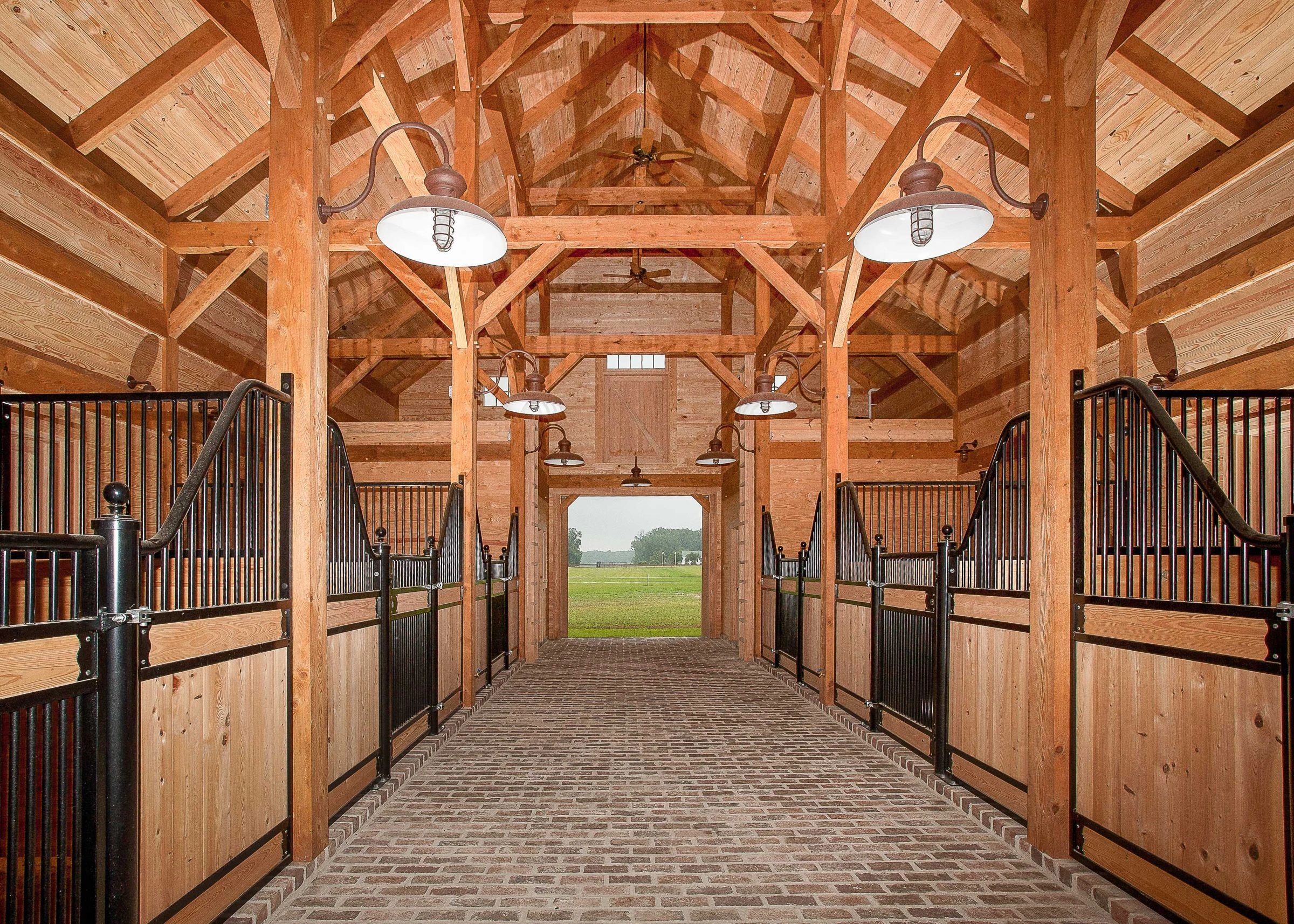 Timber-framed horse barn interior with stalls and a central aisle