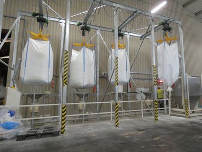Large industrial bags hanging in a factory setting.