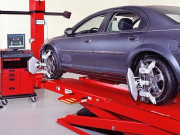 Car undergoing wheel alignment on a lift.