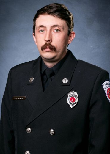 Portrait of a firefighter in formal uniform with badges and insignia.