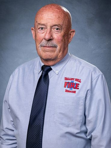 An elderly man in a Valley Hill Fire Rescue uniform shirt and tie.