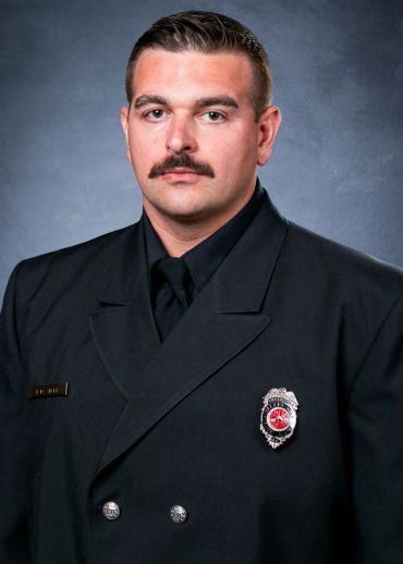 Portrait of a firefighter in uniform with a mustache.