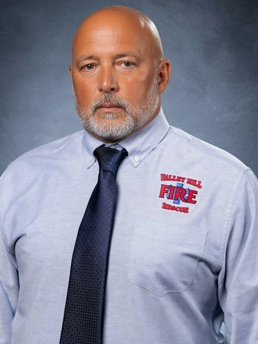 Portrait of a serious man in a fire rescue uniform shirt and tie.