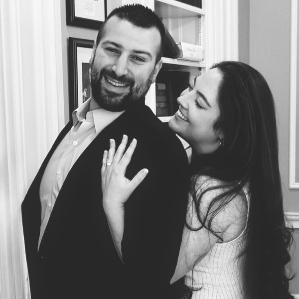 Happy couple sharing a joyful moment, showing an engagement ring.
