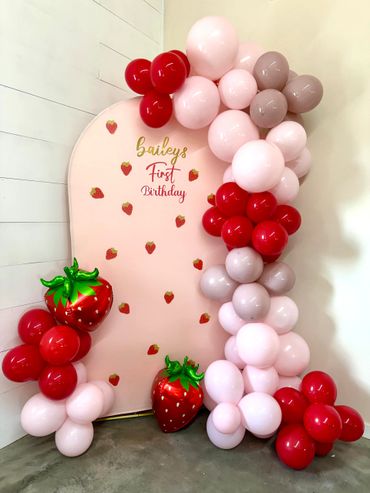 Colorful balloon arch and strawberries decoration for Bailey's first birthday.