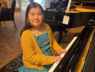 Young girl posing by piano in St Louis