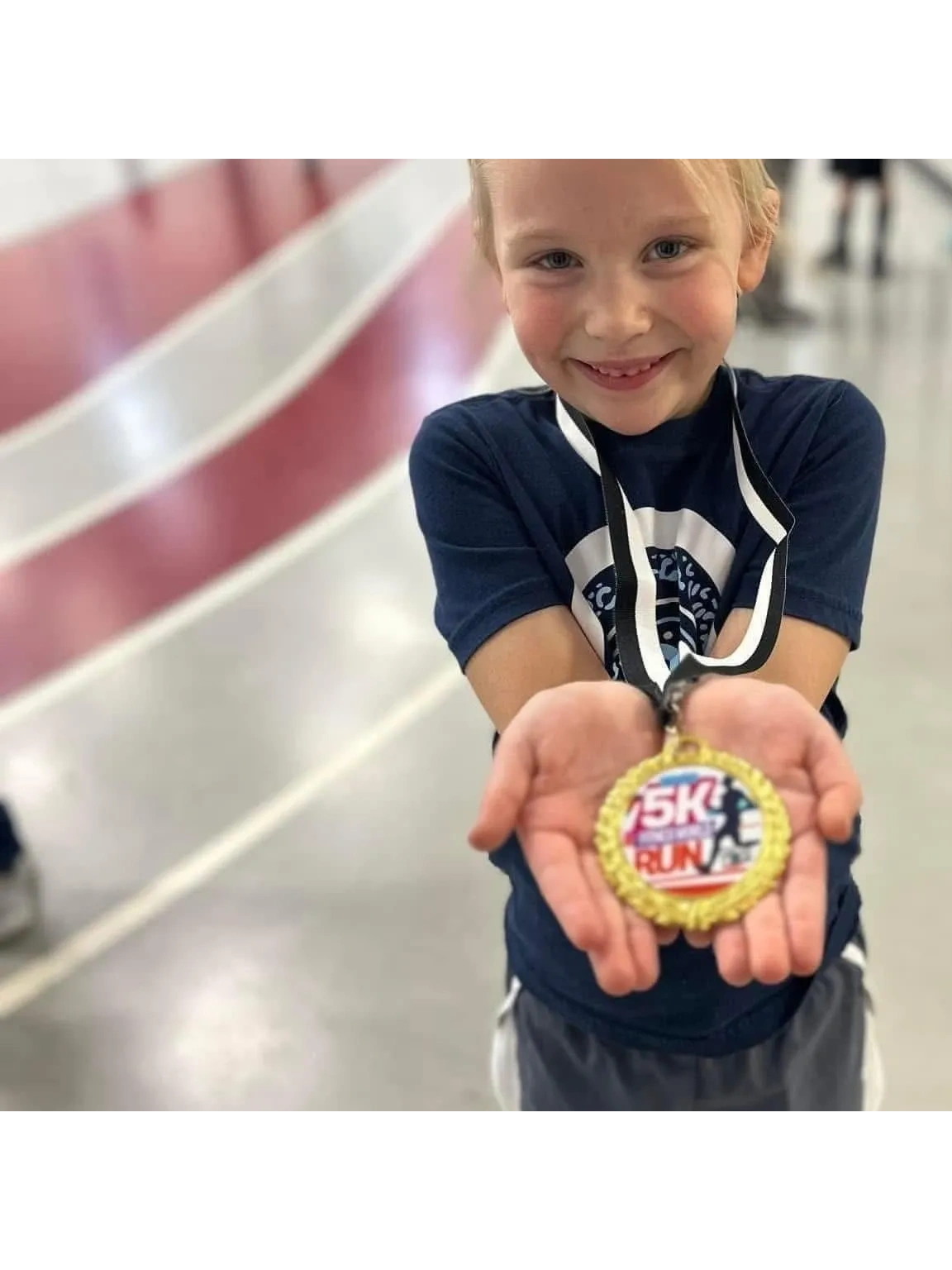 Child proudly holding a 5K finisher medal
