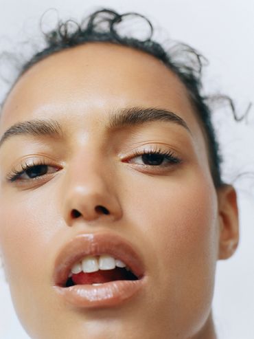 Close-up of a woman's face with natural skin and slightly open lips.