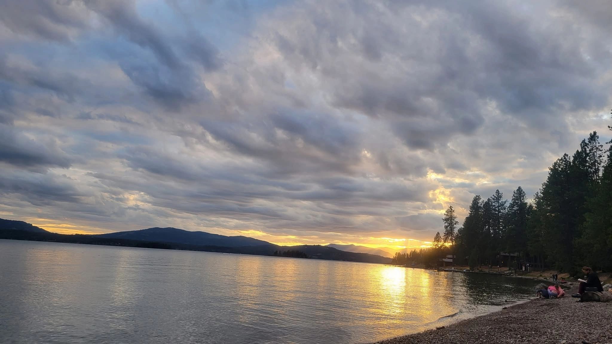 Sunset over Lake Pend Oreille with a cozy campfire in North Idaho | Roots Realty NW