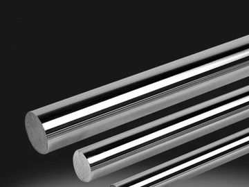Three shiny metal rods of varying thickness on a dark background.