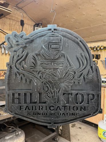 Metal sign of a welder with deer antlers for Hill Top Fabrication.