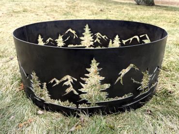 Metal fire pit with mountain and tree cutout designs.
