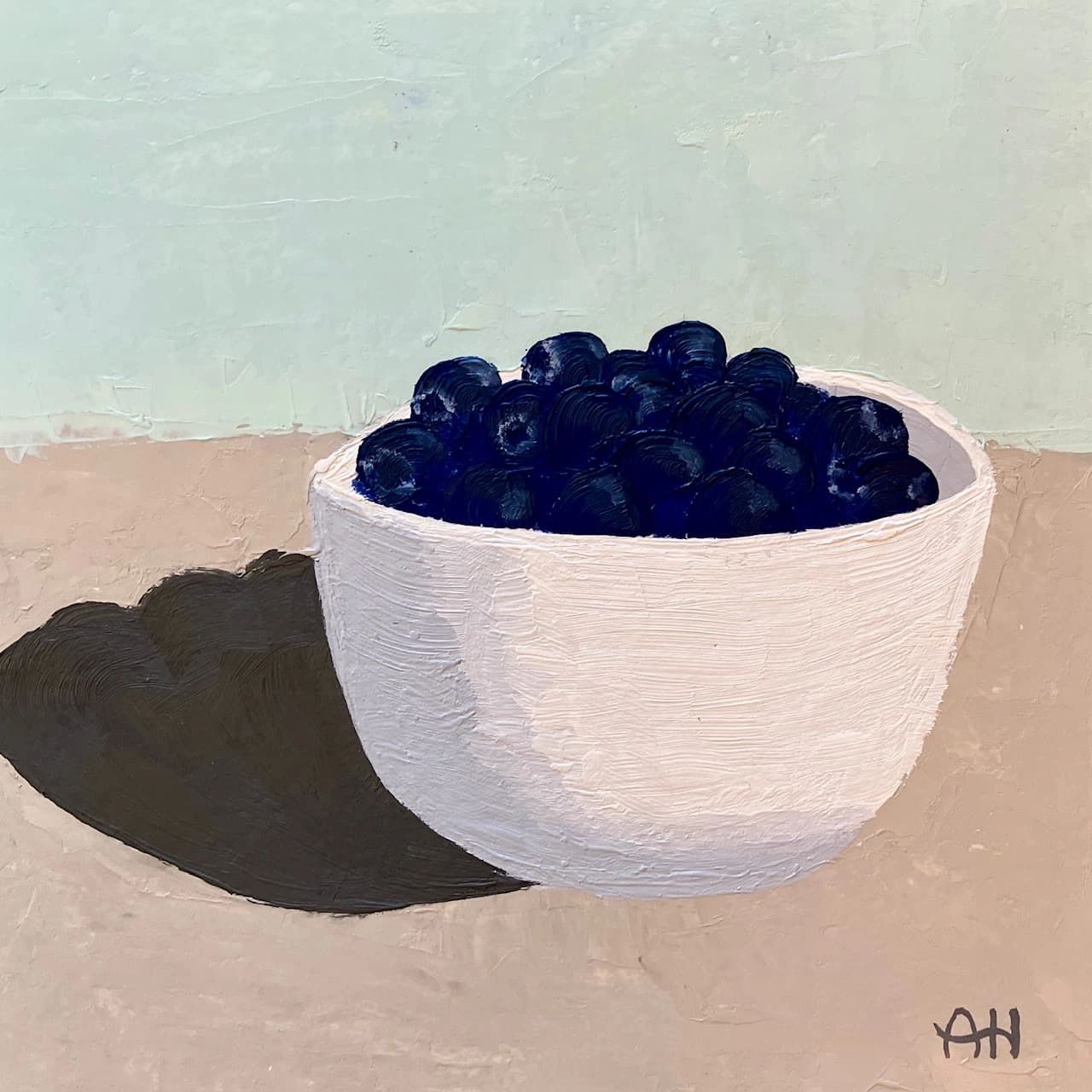 A bowl filled with dark blueberries casting a shadow.