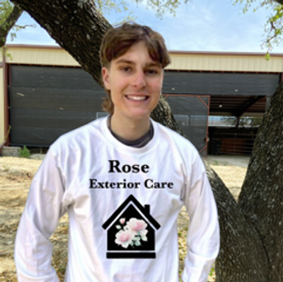 Person smiling outdoors wearing a Rose Exterior Care shirt.