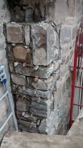 Démantèlement d'un coin en pierre naturelle sur un église afin de le replacer et solidifié le coin.