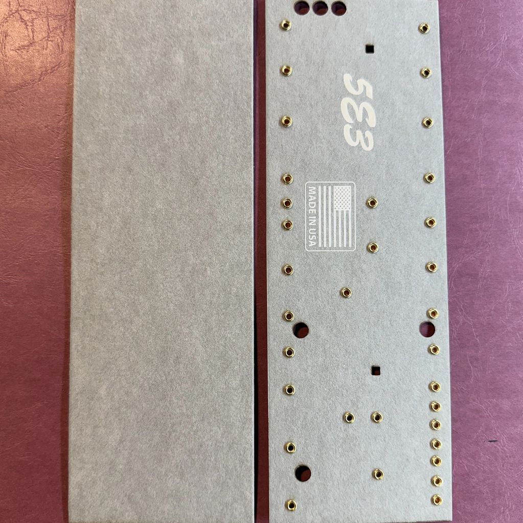 Two gray rectangular panels, one with gold eyelets and holes, labeled '533' and 'Made in USA'.