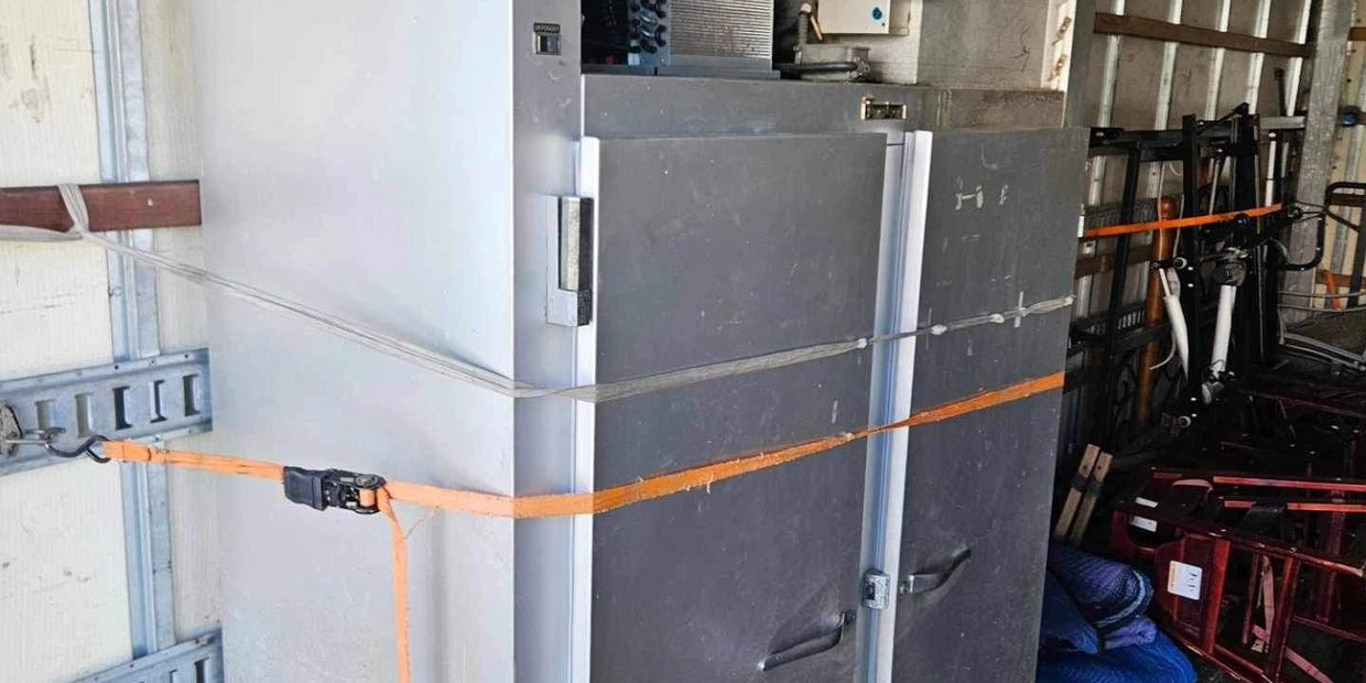 Commercial refrigerator that is no longer working being removed by Move It Junk Removal