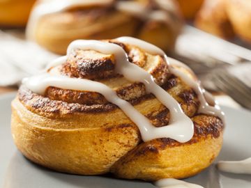 Vanilla icing packets drizzled on cinnamon buns