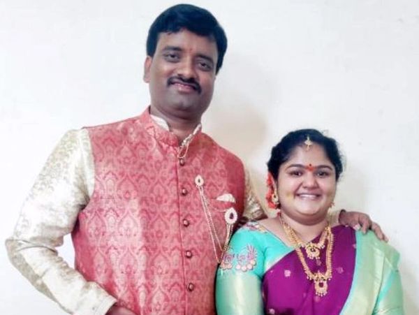 A smiling couple dressed in traditional Indian attire posing for a photo.