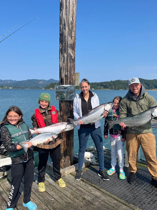 Guest on Sooke fishing charters holding a large Chinook Salmon