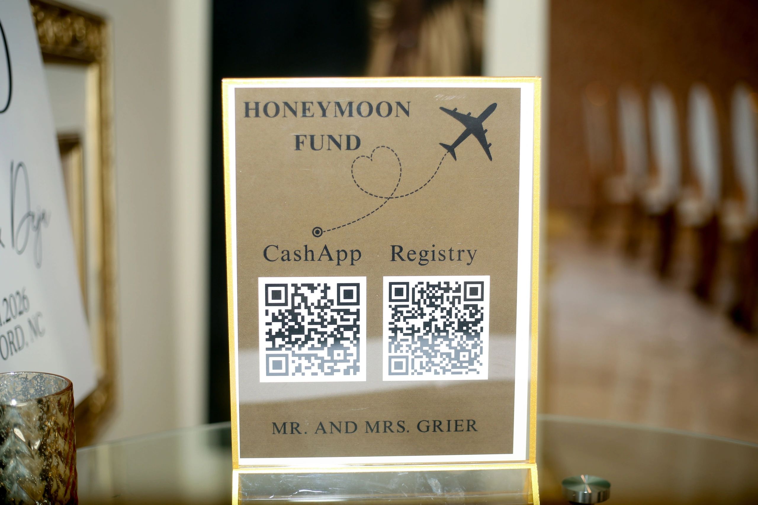 A honeymoon fund sign with QR codes for CashApp and Registry donations.
