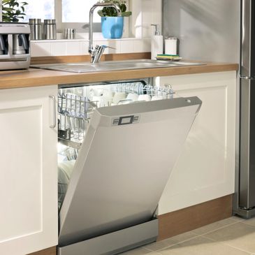 A dishwasher is open in the kitchen with dishes.