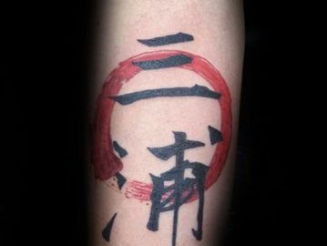 Tattoo of black Japanese kanji and a red circle on forearm.