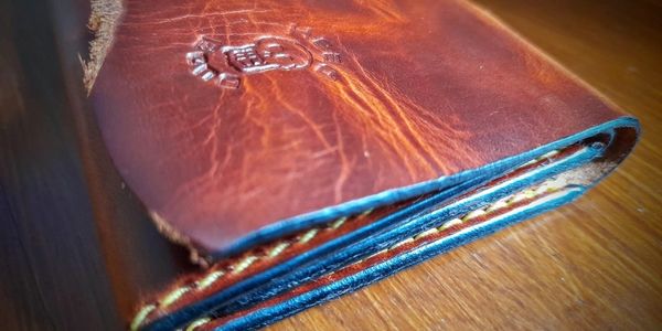 brown leather wallet on wooden table
