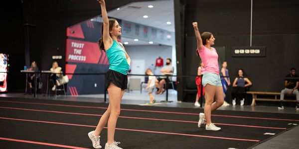 Two athletes practicing their cheer motions in a class at BlackWatch Cheer in Birmingham, Alabama