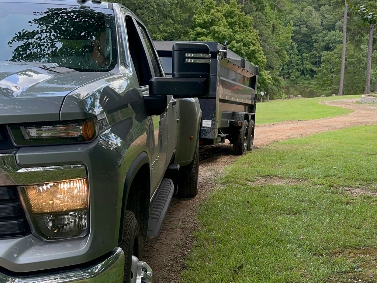 Truck with dump trailer hauling material
