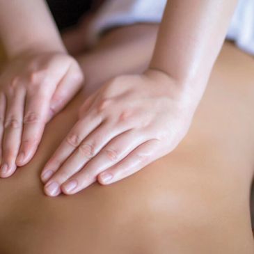 Hands giving a relaxing back massage.