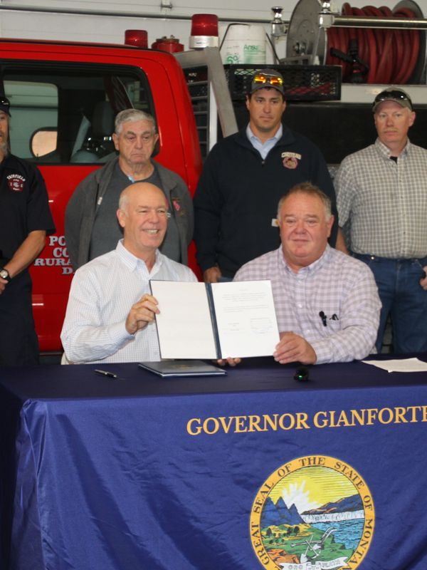 Governor Gianforte signs Rep. Llew Jones's wildfire bills with Montana firefighters.