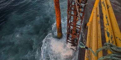 Rusty metal structure on a boat over ocean water during sunset.