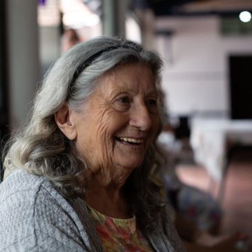 Smiling elderly woman with gray hair indoors.