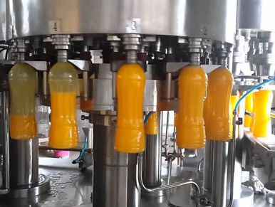 Automatic bottling machine filling juice bottles.