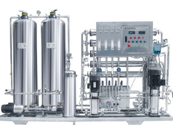 Industrial water purification system with steel tanks and control panel.