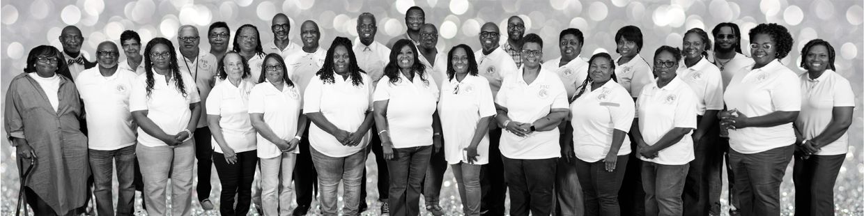 A large group of adults wearing matching white shirts posing for a black-and-white photo.