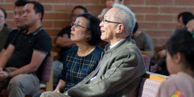 Elderly man and woman attentively listening in an indoor setting.