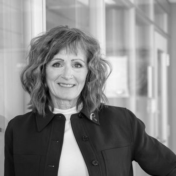 Smiling woman with wavy hair in a professional setting.