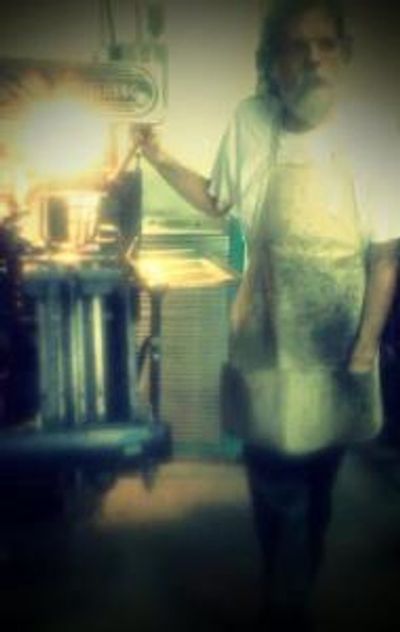 Bearded man wearing industrial apron.