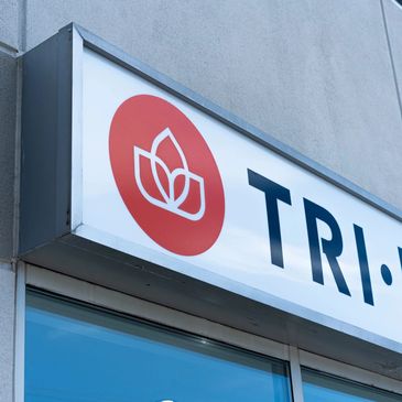 Store sign with a red circular logo and partial text 'TRI HEA'.