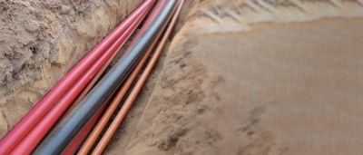 Multiple utility pipes laid in a trench for underground installation.