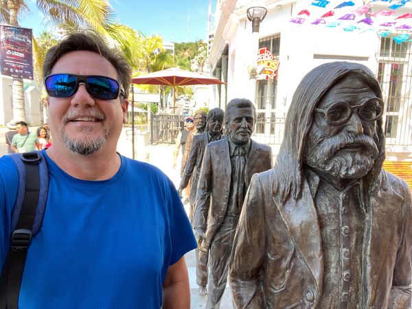 Image of the Traveler's Caddy with the Beatles tribute statues in Mazatlán.