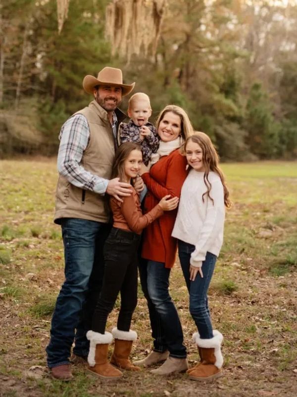 Happy family of five posing outdoors in cozy fall attire.
